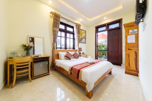 a bedroom with a bed and a desk and a television at Xuan Truong Central Dalat-1 min walk to Xuan Huong Lake in Da Lat