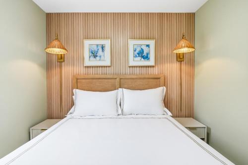a bedroom with a large white bed with two lights at The Marilyn Inn in Ocean Grove