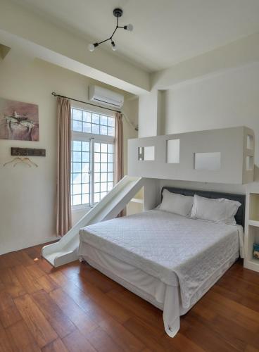 a white bedroom with a bed and a window at Bonjour日安摩墅 包棟 單間 in Hengchun South Gate