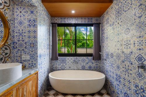 a bathroom with a tub and a window at Ubud Mesari Private Pool Villa in Ubud