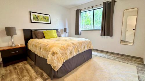 a bedroom with a bed and a window and a mirror at Holualoa Gardens 101 in Kailua-Kona