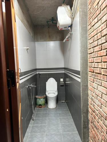 a small bathroom with a toilet in a stall at ANOR Farmstay - Two Double Bed in Hue