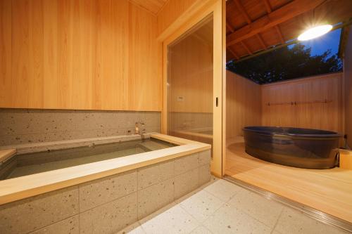 a bathroom with a bath tub in a room at YASUYA-yasuya- in Yasugi