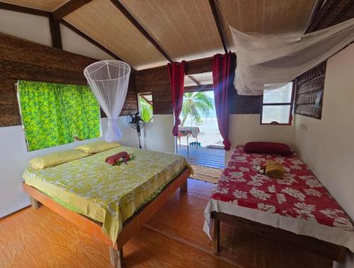 a bedroom with a bed and a window at Tikehau Herearii in Tikehau Airport