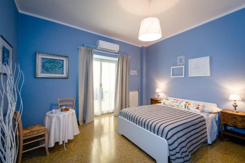 Dormitorio azul con cama y ventana en B&B I Portici Di Sottoripa, en Génova