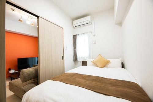 a bedroom with a large bed and a chair at SPAZIO 4 Tenjin Minami in Fukuoka