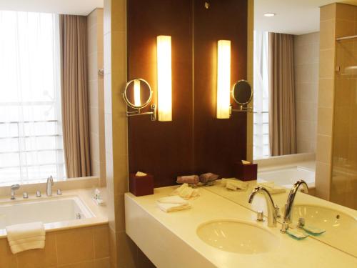 a bathroom with a sink and a tub and a mirror at Wanshang Garden Hotel in Beijing