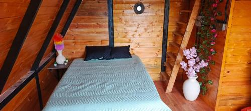 a bed in a room with two vases at Glamping Jadiva in Cucunubá