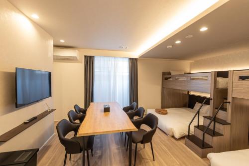 a room with a table and chairs and a bunk bed at ReLA Kashiwa Eki Nishi in Kashiwa