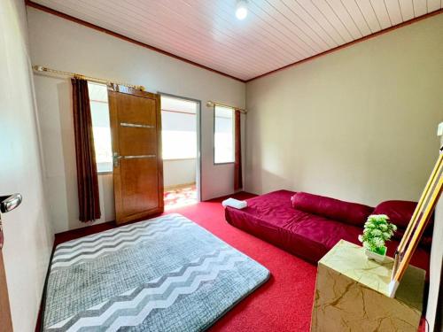 a living room with a red couch and a red rug at Nara Hills in Sembalun Lawang