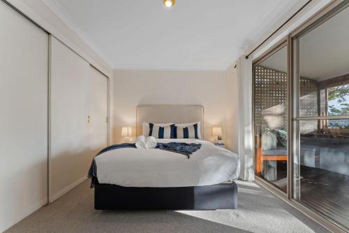 a bedroom with a large bed and a large window at Flannel Flower Beach House in Shoal Bay