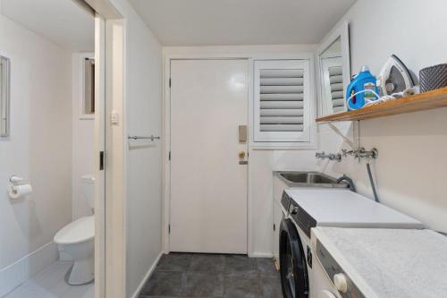 a small bathroom with a sink and a toilet at Flannel Flower Beach House in Shoal Bay