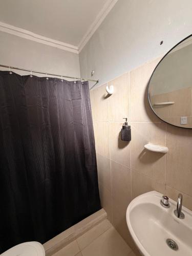 a bathroom with a black shower curtain and a sink at Duna Blanca I in Fiambalá