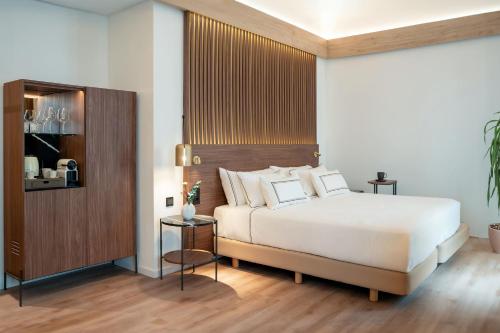 a bedroom with a white bed and a wooden headboard at Meliá Granada in Granada