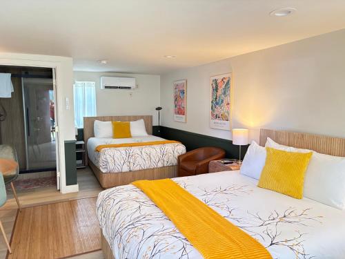 a hotel room with two beds and a chair at Riverwalk Park Inn in Chelan