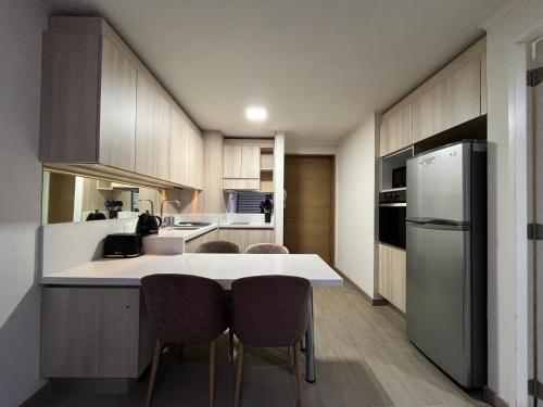 a kitchen with a white counter and a refrigerator at Lagos centro Temuco in Temuco
