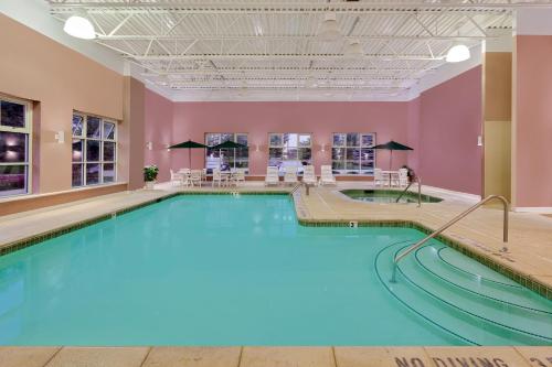 a large swimming pool in a building with pink walls at Baymont by Wyndham Grand Rapids SW/Byron Center in Byron Center