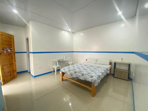a bedroom with a bed and a table in it at Juliet's Homestay in Moalboal