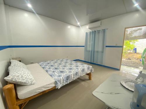 a small bedroom with a bed and a table at Juliet's Homestay in Moalboal
