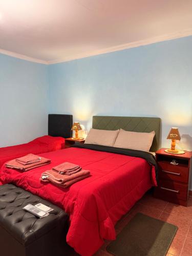 a bedroom with a bed with a red bedspread at Duna Blanca II in Fiambalá