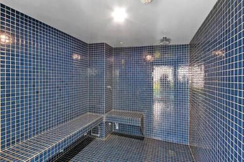 a blue tiled bathroom with a bench in it at Picnic Point Panoramic Views in Maroochydore