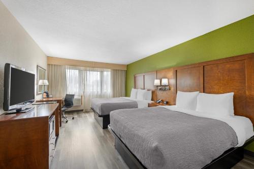 a hotel room with two beds and a flat screen tv at Quality Inn & Suites Goshen in Goshen