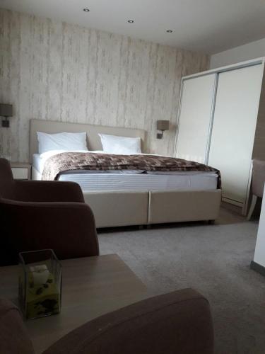 a bedroom with a large bed and a couch at Hotel Palazzo in Gornji Vakuf
