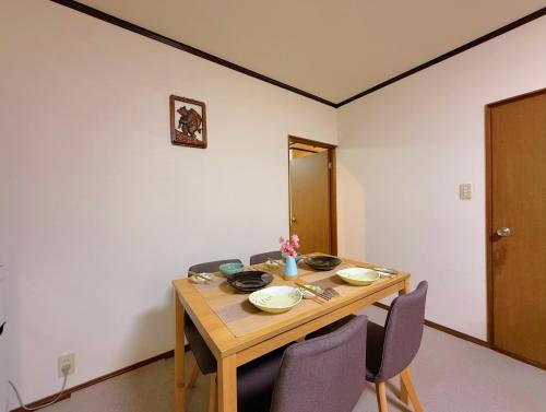 a wooden table with chairs in a room at Ema-長吉 in Osaka