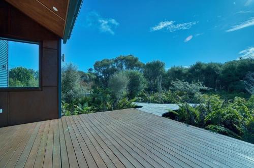 a house with a wooden deck with a view at Fern View - Cozy 2-bedroom house in Hokitika