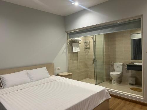 a bedroom with a bed and a shower and a toilet at Emerald Marina TL in Phú Quốc