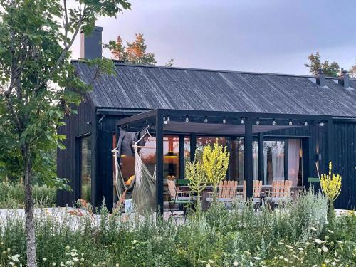a black house with a garden in front of it at Architect-Designed House In Etelhem, Gotland in Stånga