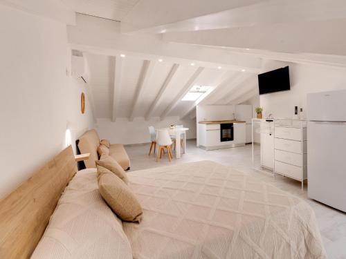 a living room with a couch and a kitchen at Brand new attic studio apartment, air conditioned in Castelsardo