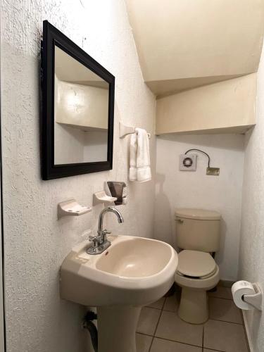 a bathroom with a sink and a toilet and a mirror at Casa privada con estacionamiento in Hermosillo
