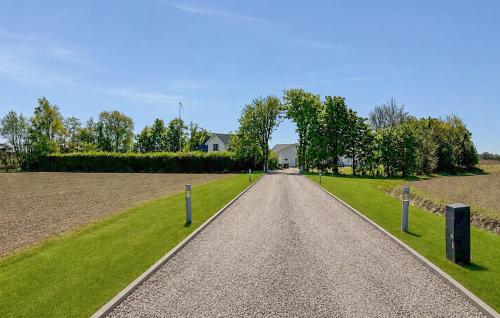 a gravel road with a house in the distance at Nice Home In Hadsund With Sauna in Hadsund