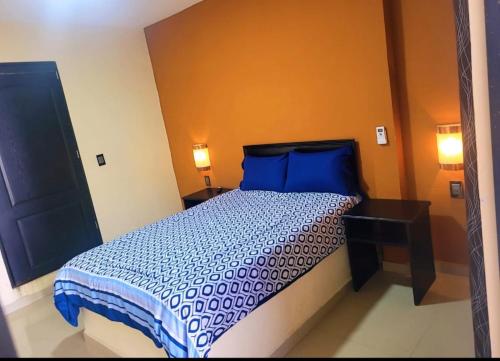 a bedroom with a bed with blue sheets and blue pillows at hotel del valle in Coatzacoalcos