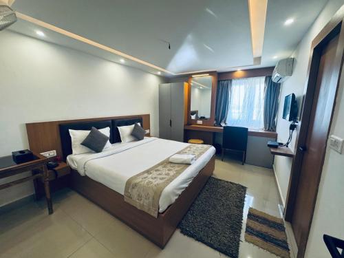 a bedroom with a large bed and a television at Hotel Vaishnavi Heights in Aurangābād