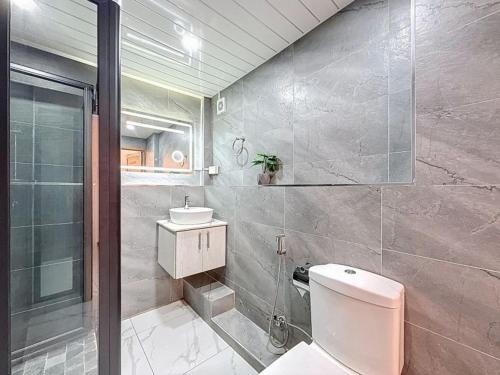 a bathroom with a toilet and a sink and a shower at Les Sables Roses Appartement in Flic-en-Flac