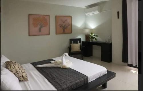a bedroom with a bed with a swan on it at SanRosa Boutique Hotel BnB in Bulalakao