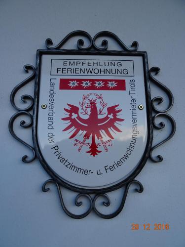 a sign on a wall with a red and white sign at Gästehaus Maria in Kartitsch