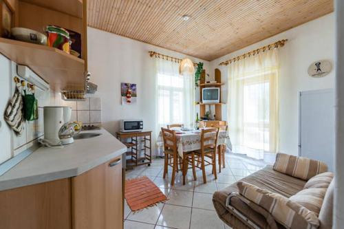 a kitchen and living room with a couch and a table at Apartments LIMA Lazaneo in Jelsa