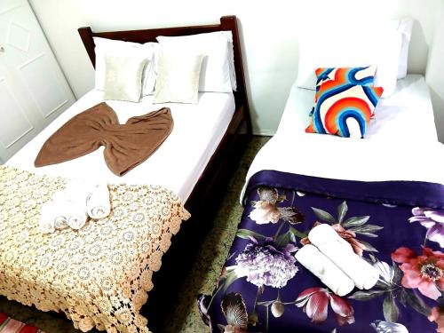 two beds in a hotel room with towels on them at Emerald Oceano Mar in Copacabana
