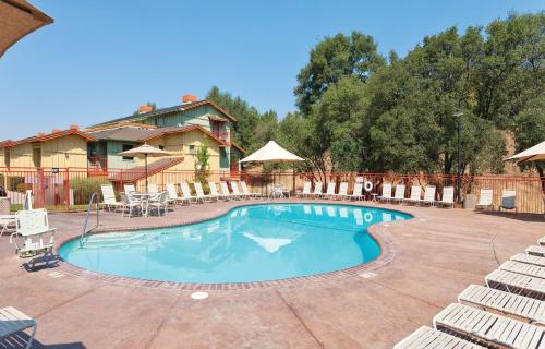 a swimming pool at a resort with chairs and tables at Angels Camp Resort 3BR Apartment in Angels Camp