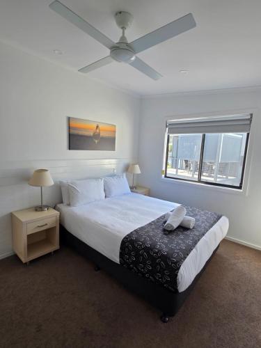 a bedroom with a large bed with a ceiling fan at Kingston Foreshore Caravan Park in Kingston South East