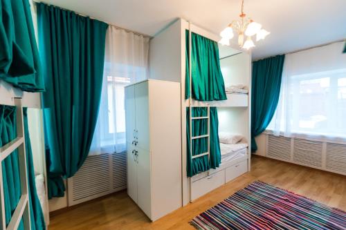 a bedroom with green curtains and bunk beds at Interhouse Almaty in Almaty