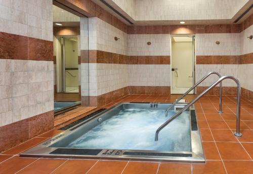 a hot tub in a bathroom with two mirrors at The Donatello Resort Studio Apartment in San Francisco