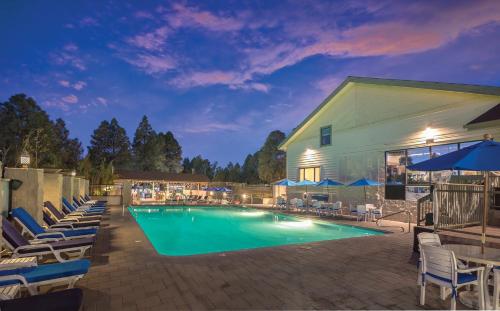 a swimming pool with lounge chairs and umbrellas at night at Flagstaff Resort 2BR Apartment in Flagstaff