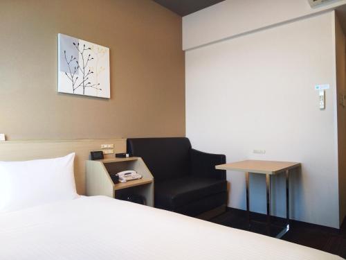 a bedroom with a bed and a chair and a table at Hotel Route Inn Ono in Ono