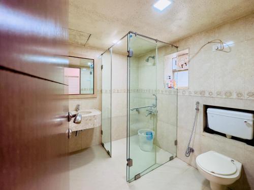 a bathroom with a glass shower and a toilet at Spellbound in Wadgaon