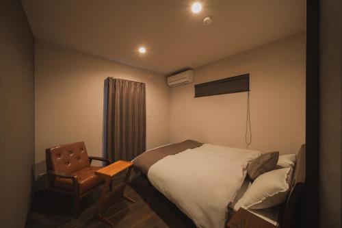 a hotel room with a bed and a chair at みたまの湯宿 in Beppu
