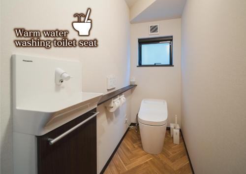a small bathroom with a toilet and a sink at みたまの湯宿 in Beppu